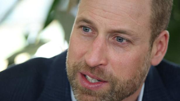 Prinz William mit Bart und blauem Sakko spricht.