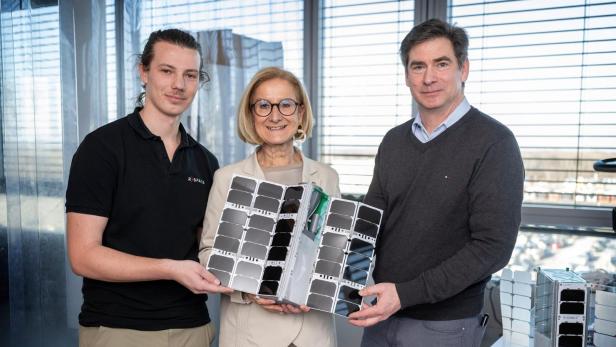 Zwei Männer und eine Frau blicken in die Kamera