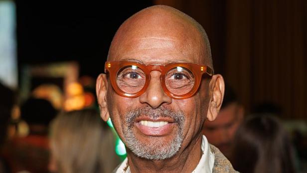 Pierre Sanoussi-Bliss lächelt mit großer Brille.