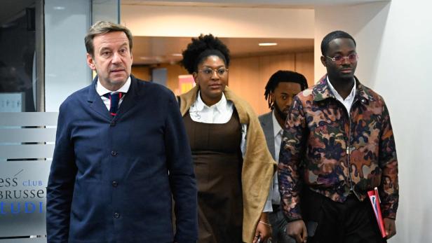 Mehrere Personen gehen durch einen Gang ins Gericht