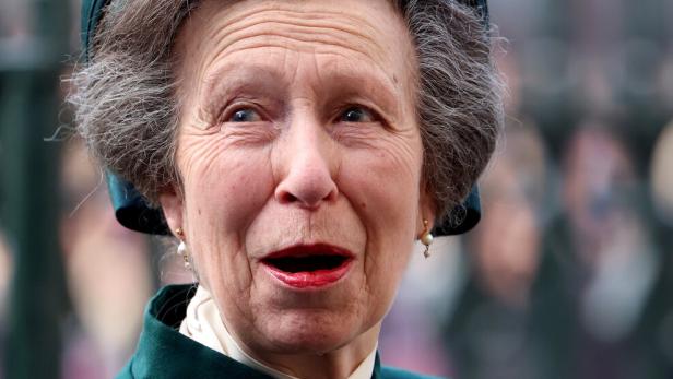 Prinzessin Anne trägt einen grünen Hut und Mantel mit einer Brosche und rotem Lippenstift.