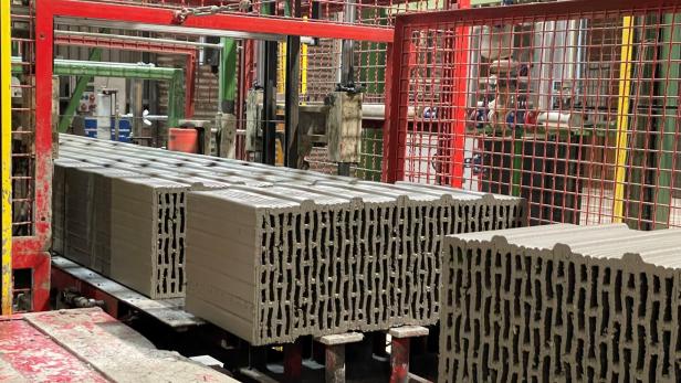 Auf einem Fließband sind Ziegel der Firma Wienerberger zu sehen.