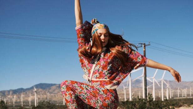 Eine Frau in der Wüste mit einem Blumen-Einteiler