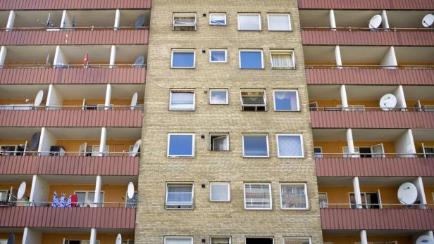 Ein mehrstöckiges Wohnhaus mit Balkonen und Satellitenschüsseln.