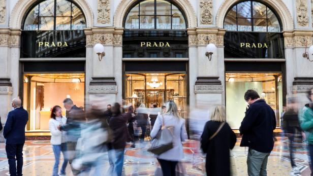 FILE PHOTO: People walk past a Prada store in Galleria Vittorio Emanuele II in Milan