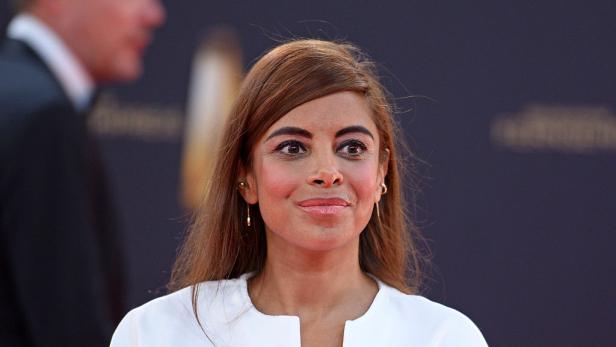 Collien Ulmen in einem weißen Oberteil vor unscharfem Hintergrund.