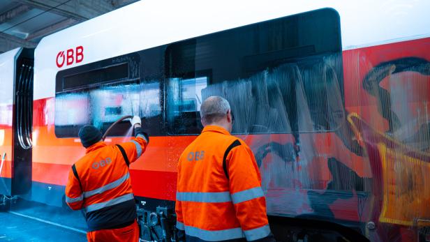 ÖBB-Personl entfernt Graffitis von Zug