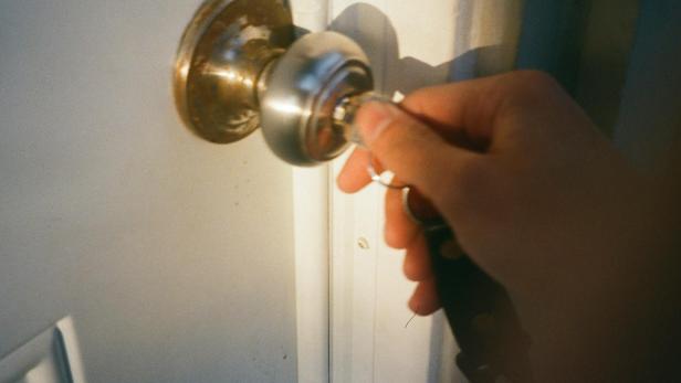Person, die Wohnungstüre aufsperrt