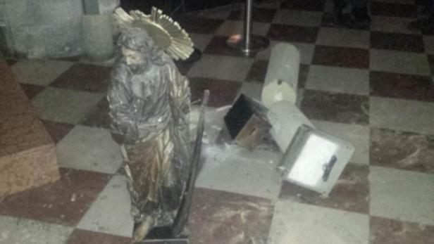 Eine Statue steht inmitten von Trümmern auf einem Schachbrettmusterboden.