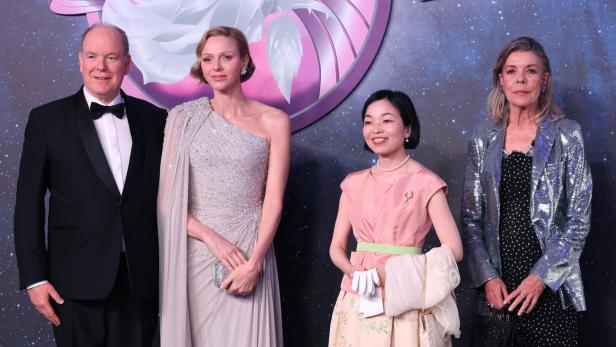 Fürst Albert II., Charlène von Monaco und Caroline posieren vor einem Hintergrund mit Weltraummotiv.