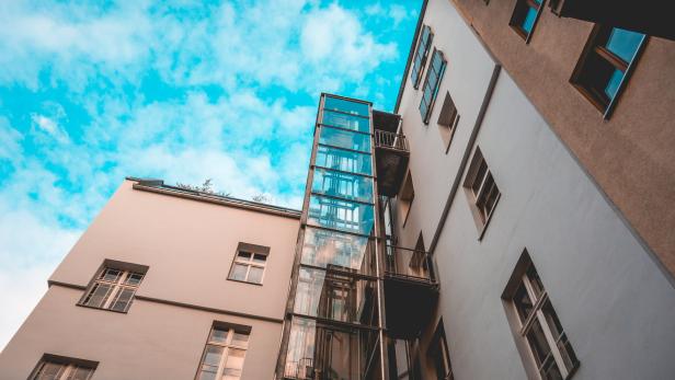 glass elevator at apartment house with fluffy background sky