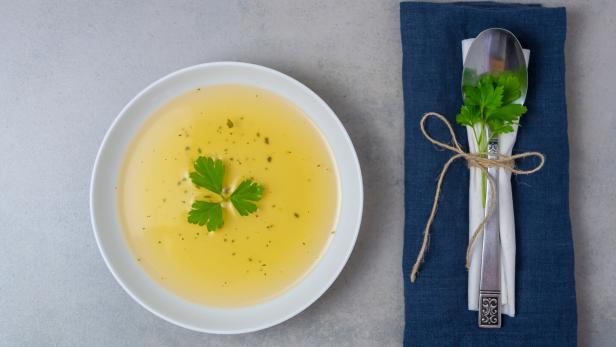 Clear soup with fresh parsley
