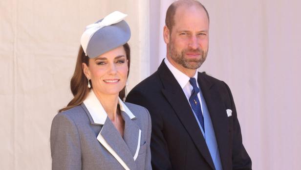 Kate und William posieren, sie trägt einen grauen Hut und einen Blazer.