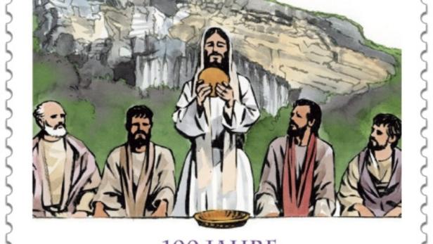 Fünf Männer in historischen Gewändern sitzen und stehen vor einer Felswand, einer hält ein Brot hoch.