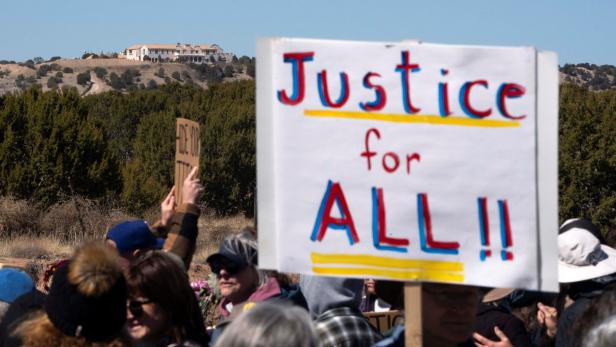 Zorro Ranch, a property formerly owned by Jeffrey Epstein, stands behind a protest sign that reads "Justice for all" on International Womens Day near Stanley
