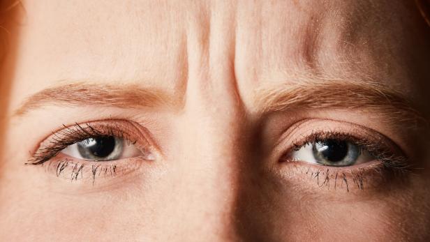 Beautiful but frowning young redhead in cropped close-up