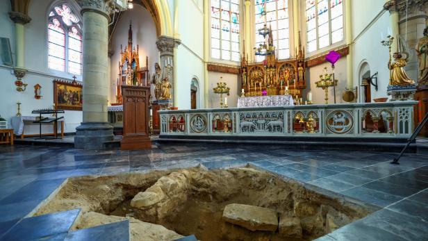 In einer Kirche ist ein Loch im Boden zu sehen, vermutlich für archäologische Ausgrabungen.