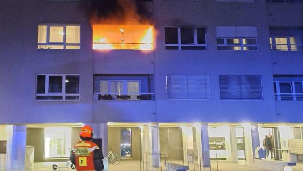 Feuerwehrmann vor brennendem Gebäude