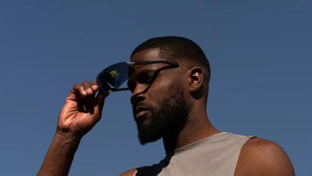 Ein Sportler setzt die Engo3-Smartbrille auf, die Trainingsdaten direkt im Sichtfeld anzeigt.