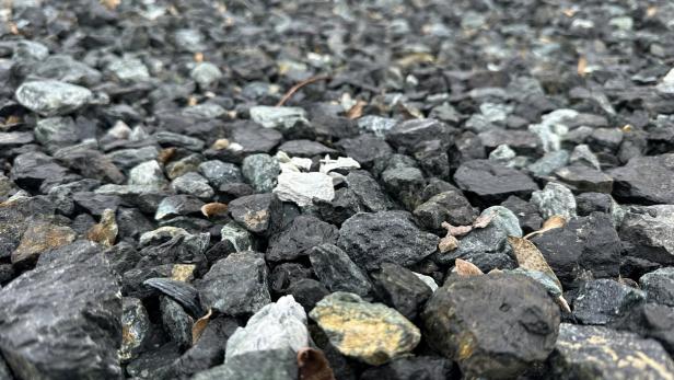 Viele kleine, unterschiedlich gefärbte Steine liegen dicht nebeneinander auf dem Boden.