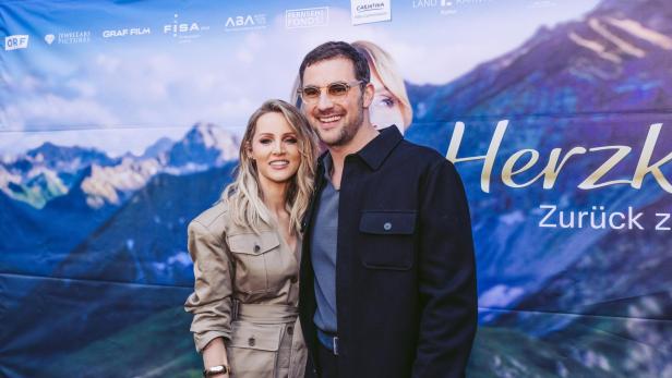 Melissa Naschenweng und Ferdinand Seebacher vor der Fotowand zum Film "Herzklang"