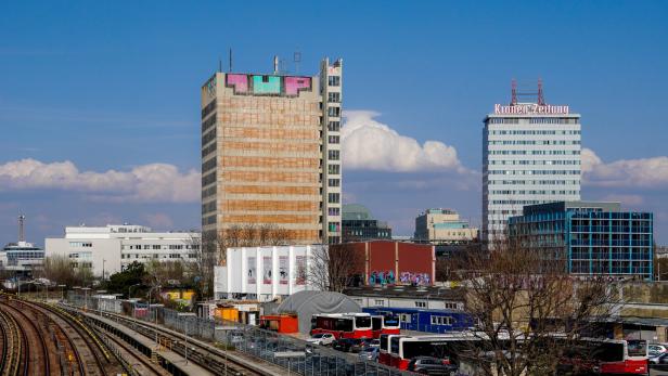 Im Vordergrund verlaufen Bahngleise, dahinter stehen Gebäude, darunter ehemalige APA-Haus.