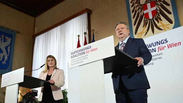 Eine Frau und ein Mann stehen an Rednerpulten mit der Aufschrift "Aufschwungs Koalition für Wien".