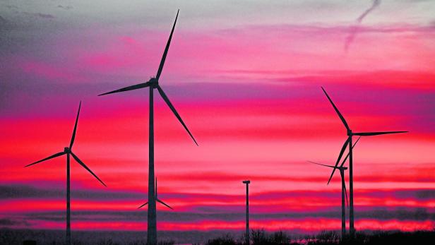 Windräder vor rotem Himmel.