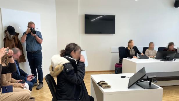 Die 32-jährige Angeklagte sitzt während der Urteilsverkündung im Wiener Gerichtssaal, umgeben von Justizpersonal und Medienvertretern.