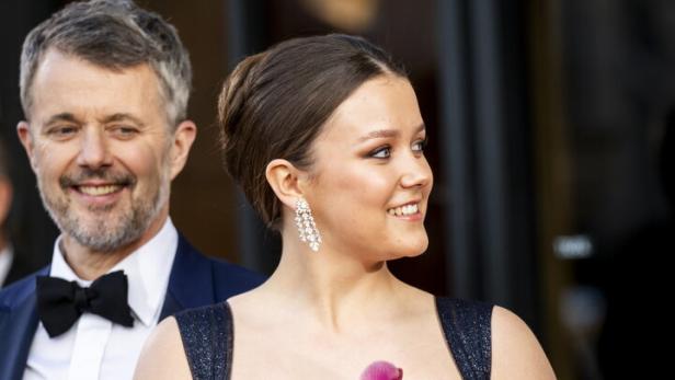 Prinzessin Isabella im Abendkleid hält einen rosa Blumenstrauß, neben ihr ein Mann im Anzug.