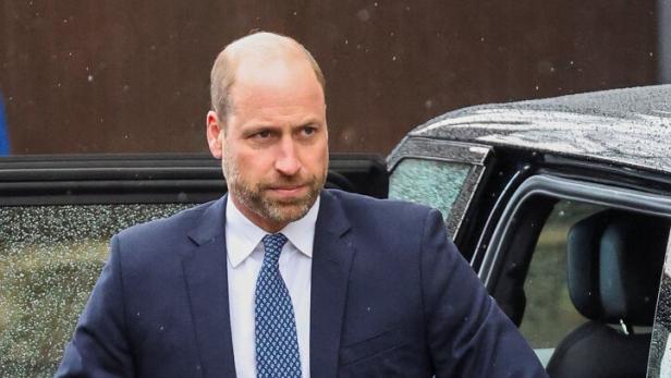 Prinz William steigt in einem dunklen Anzug und hellblauer Krawatte aus einem Auto.