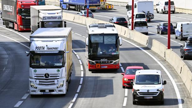 Auf einer Autobahn fahren LKW, ein Bus der Marke Setra, PKW und Transporter.