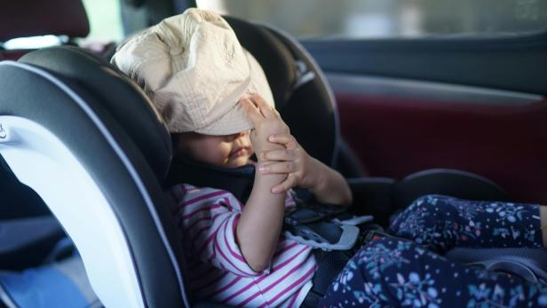 Kind im Autositz am Rücksitz eines Wagens