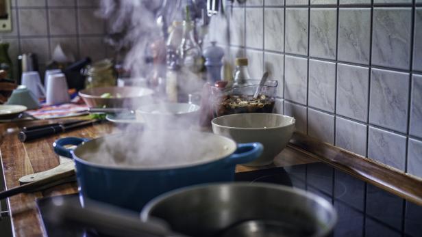 Auf dem Herd blubbert es in mehreren Töpfen und Wasserdampf steigt auf