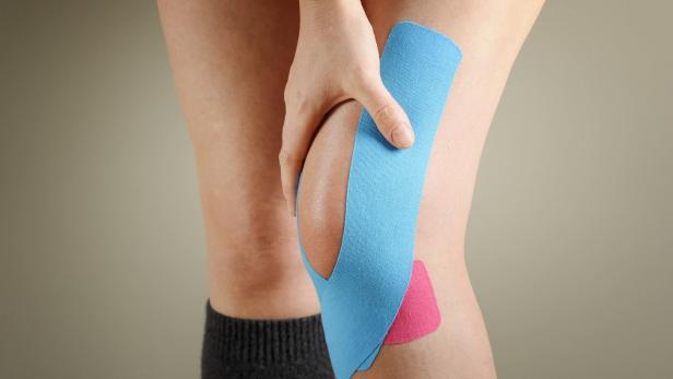 Kinesiotape auf einem Knie.