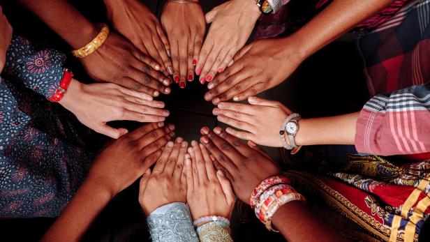 Hands of a group of multinational people which stay together in circle.