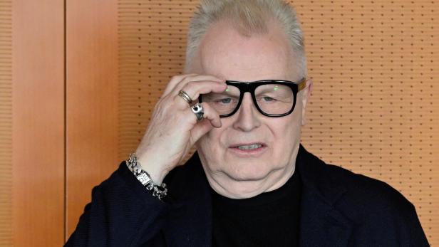 Herbert Grönemeyer mit Brille und Schmuck blickt nachdenklich in die Kamera.