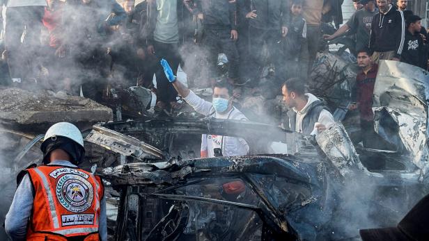 Emergency services work at the site of what medics said was an Israeli airstrike on a car near the entrance to Zawayda town