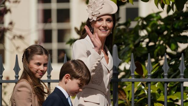 Kate, Charlotte und Louis winken vor einem Gebäude.