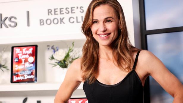 Jennifer Garner lächelt vor dem Hintergrund von "Reese's Book Club".