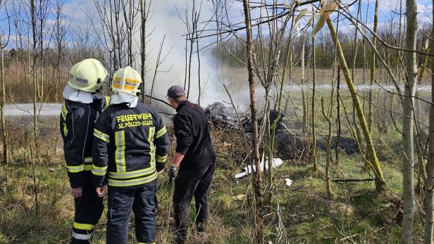 Feuerwehr löscht Wrack in einem Wald