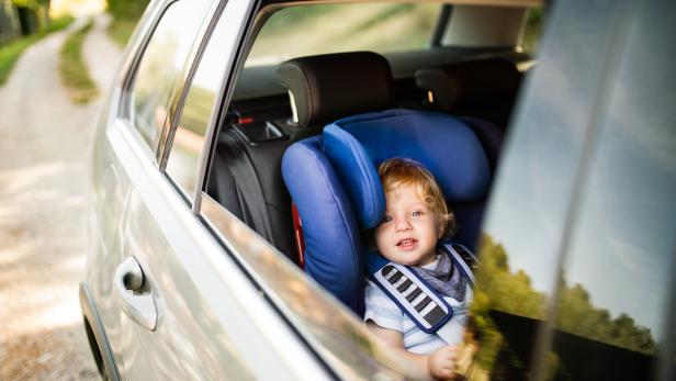 Little boy sitting in the car seat in the car.