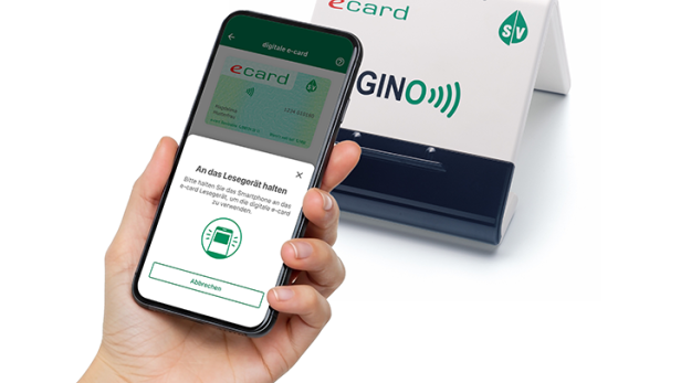 Smartphone mit digitaler E-Card vor einem GINO-Lesegerät der Sozialversicherung.