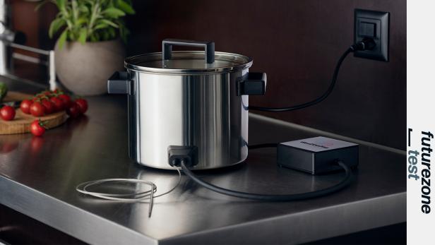 Ein vernetzter Edelstahltopf mit Elektronikbox steht auf einer Küchenarbeitsplatte.