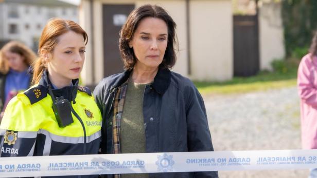 Zwei Ermittlerinnen stehen vor Absperrband am Tatort