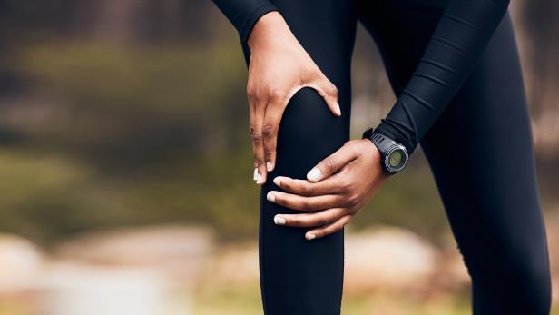 Eine Frau greift sich ans Knie.