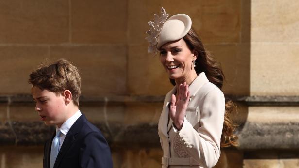 Prinzessin Kate mit Hut winkt, während Prinz George im Anzug neben ihr geht.