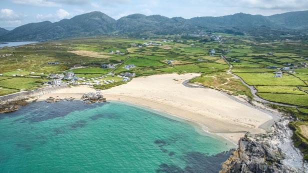 Türkises Meer, weißer Strand, grüne Felder
