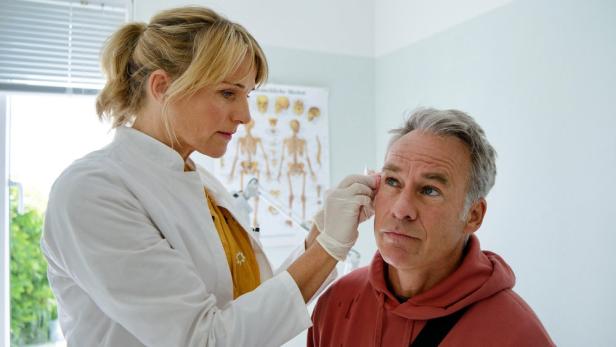 Ärztin versorgt Patienten im Gesicht