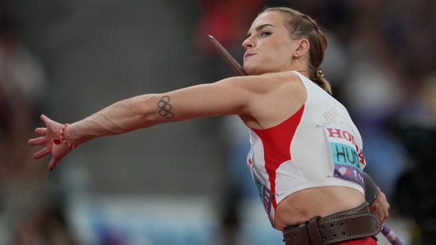 Eine Speerwerferin mit Tätowierung der olympischen Ringe bereitet sich auf den Wurf vor.